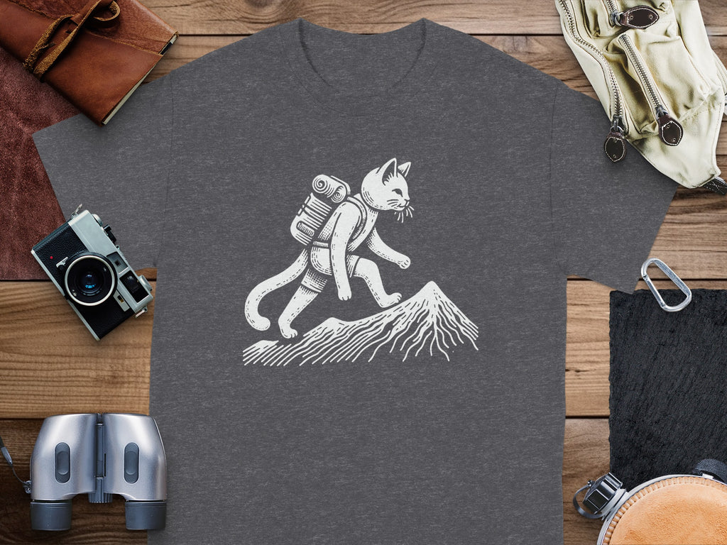 White line art cat with backpack hiking mountain on dark grey t-shirt.