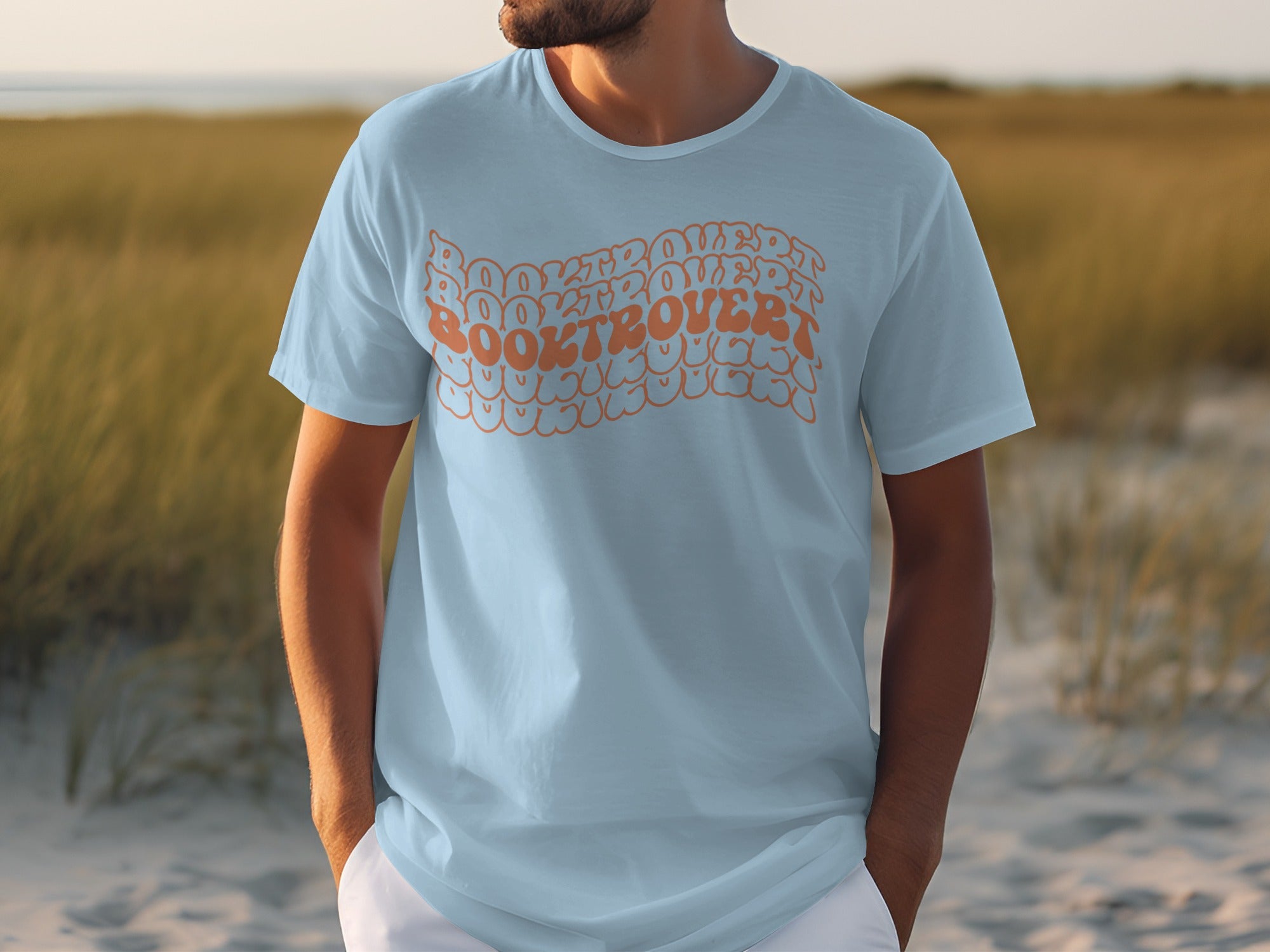Light blue t-shirt with orange wavy text reading "BOOKTROVERT BOOKTROVERT BOOKTROVERT".