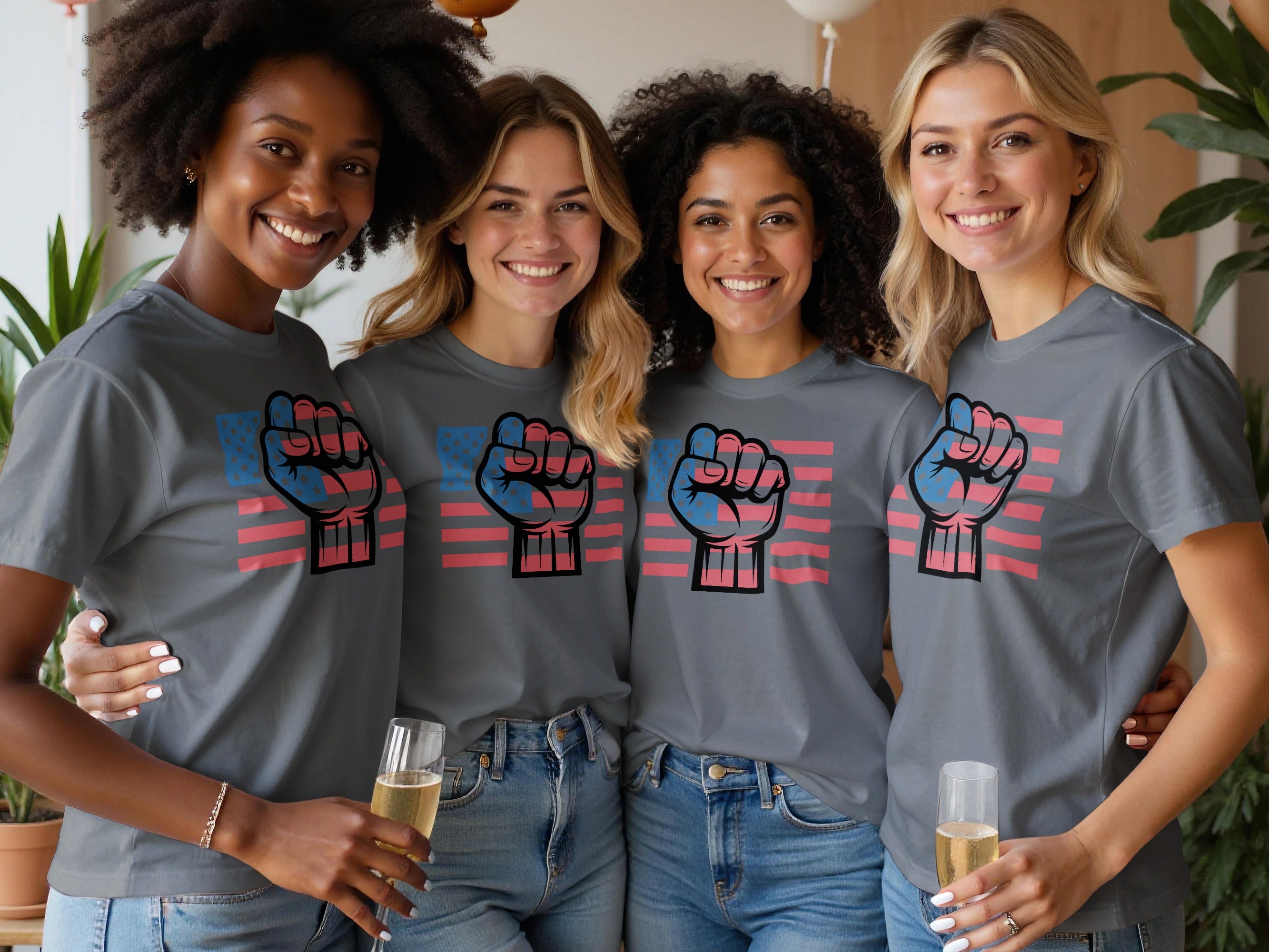 Four smiling women wear grey t-shirts with a raised fist graphic and US flag print.