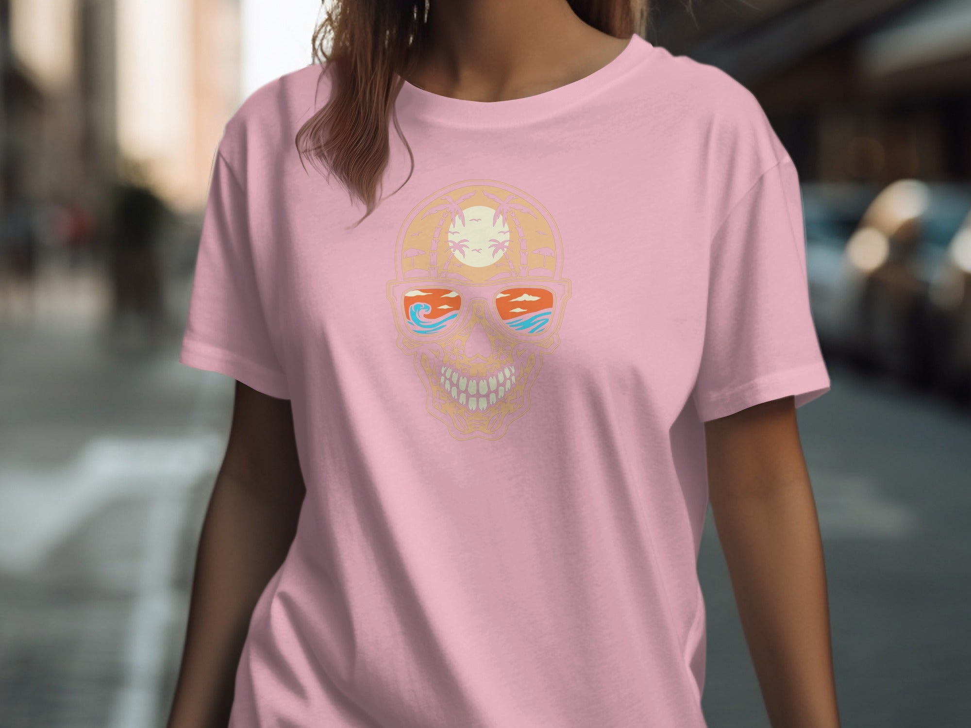 Pink t-shirt with a graphic of a skull wearing sunglasses with a beach scene.