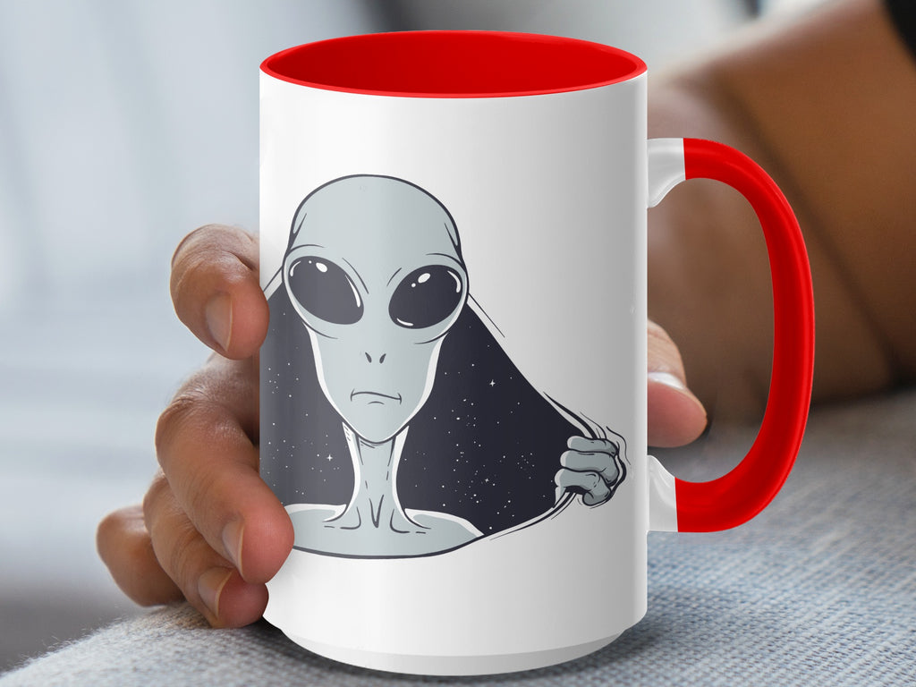 White mug with red interior and handle, featuring a gray alien peeking through a torn surface.