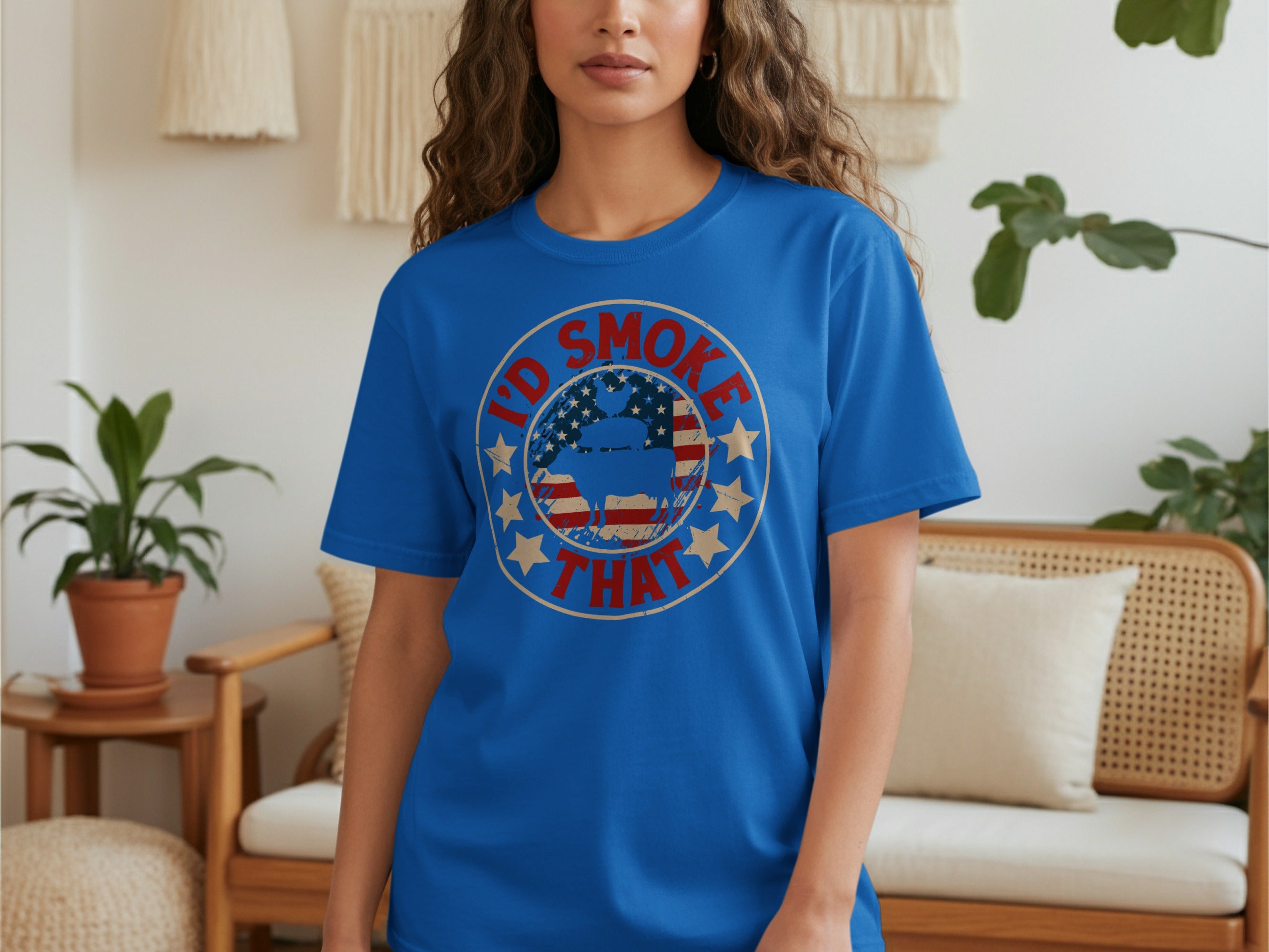 Blue t-shirt with a circular graphic, an American flag background, and the text "I'd Smoke That".