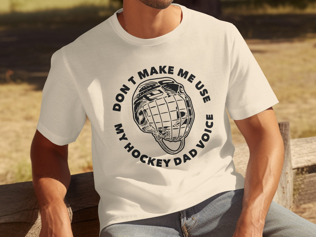 Cream t-shirt with black text and hockey helmet graphic: "DON'T MAKE ME USE MY HOCKEY DAD VOICE"