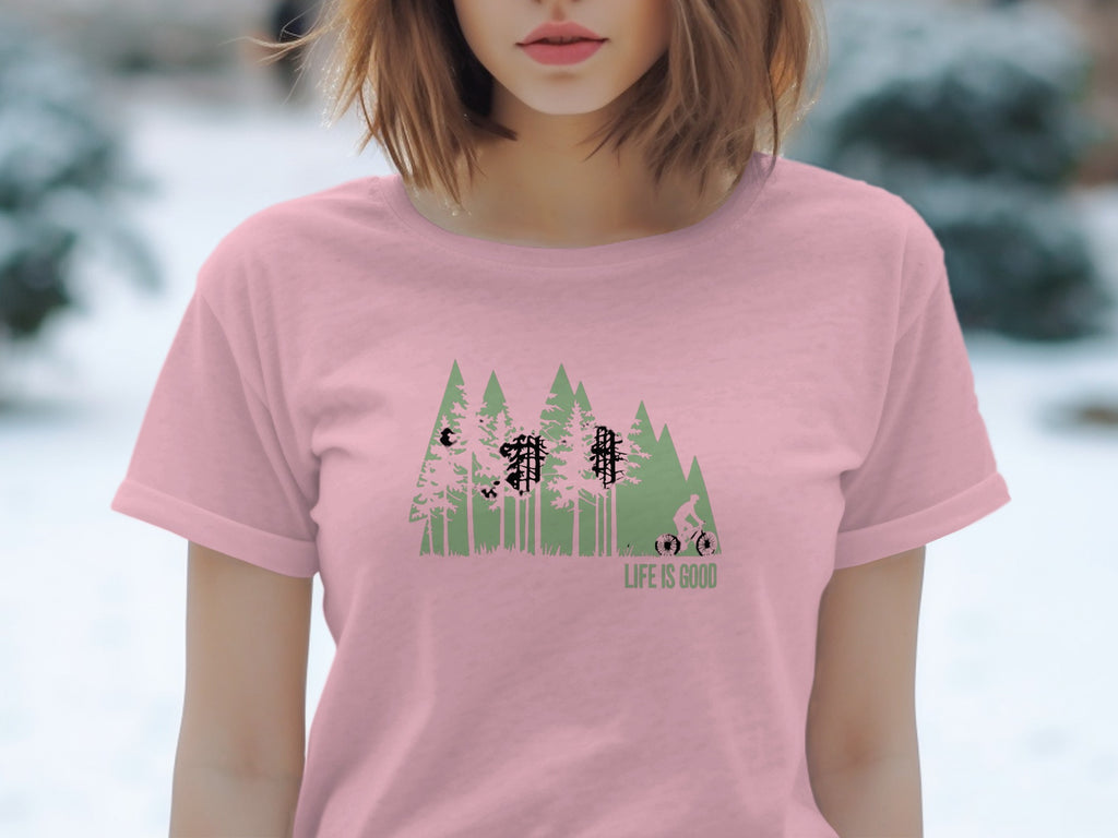 Pink t-shirt with green forest graphic, cyclist, and "LIFE IS GOOD" text.