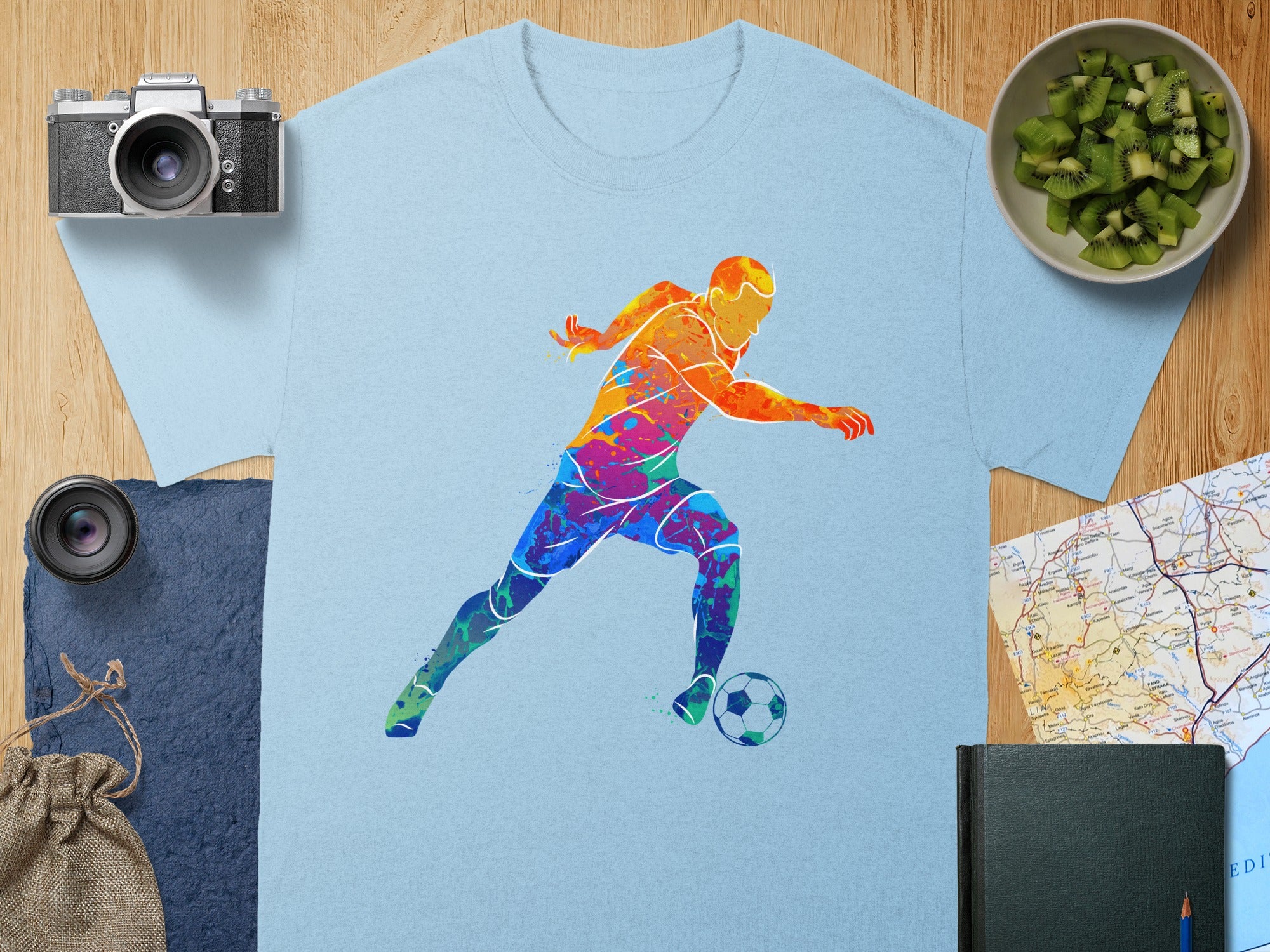 Light blue t-shirt with colorful abstract soccer player graphic.