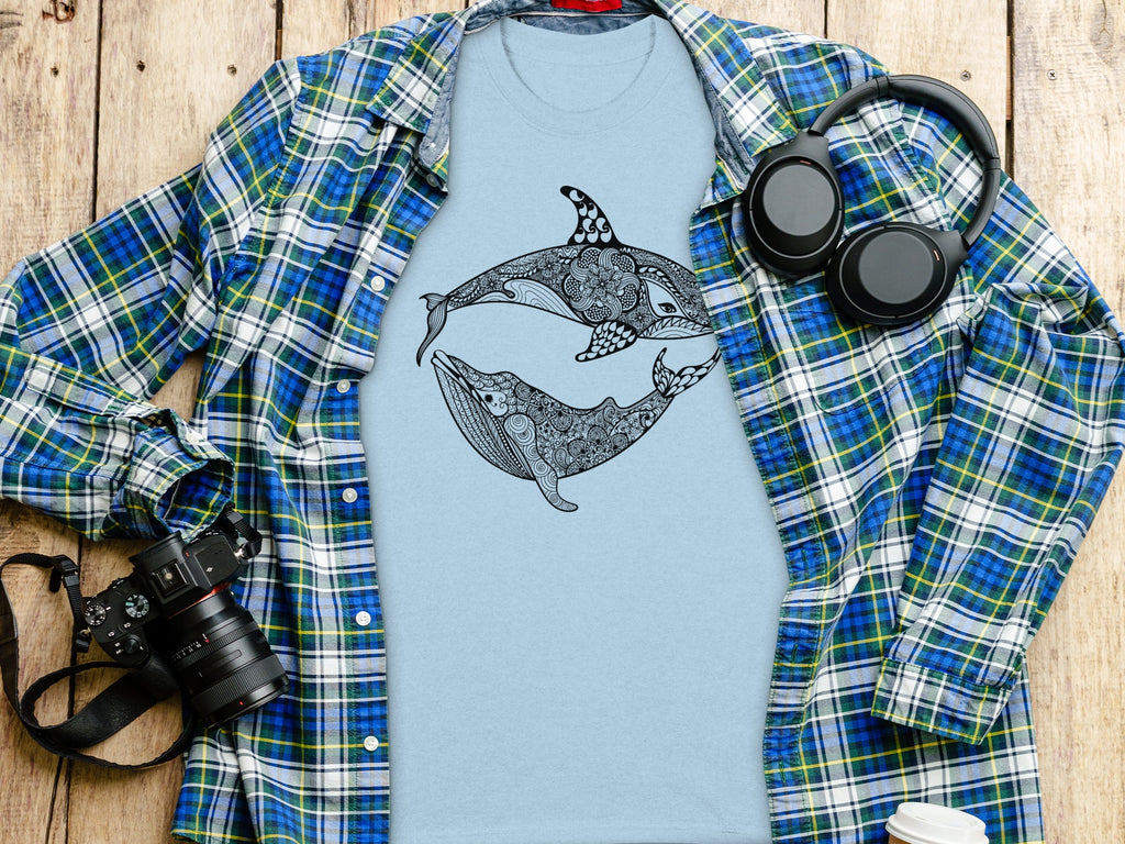 Light blue t-shirt with black orca and whale design, open plaid shirt.