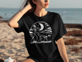 Black t-shirt with graphic of skeleton walking skeleton dog under crescent moon.