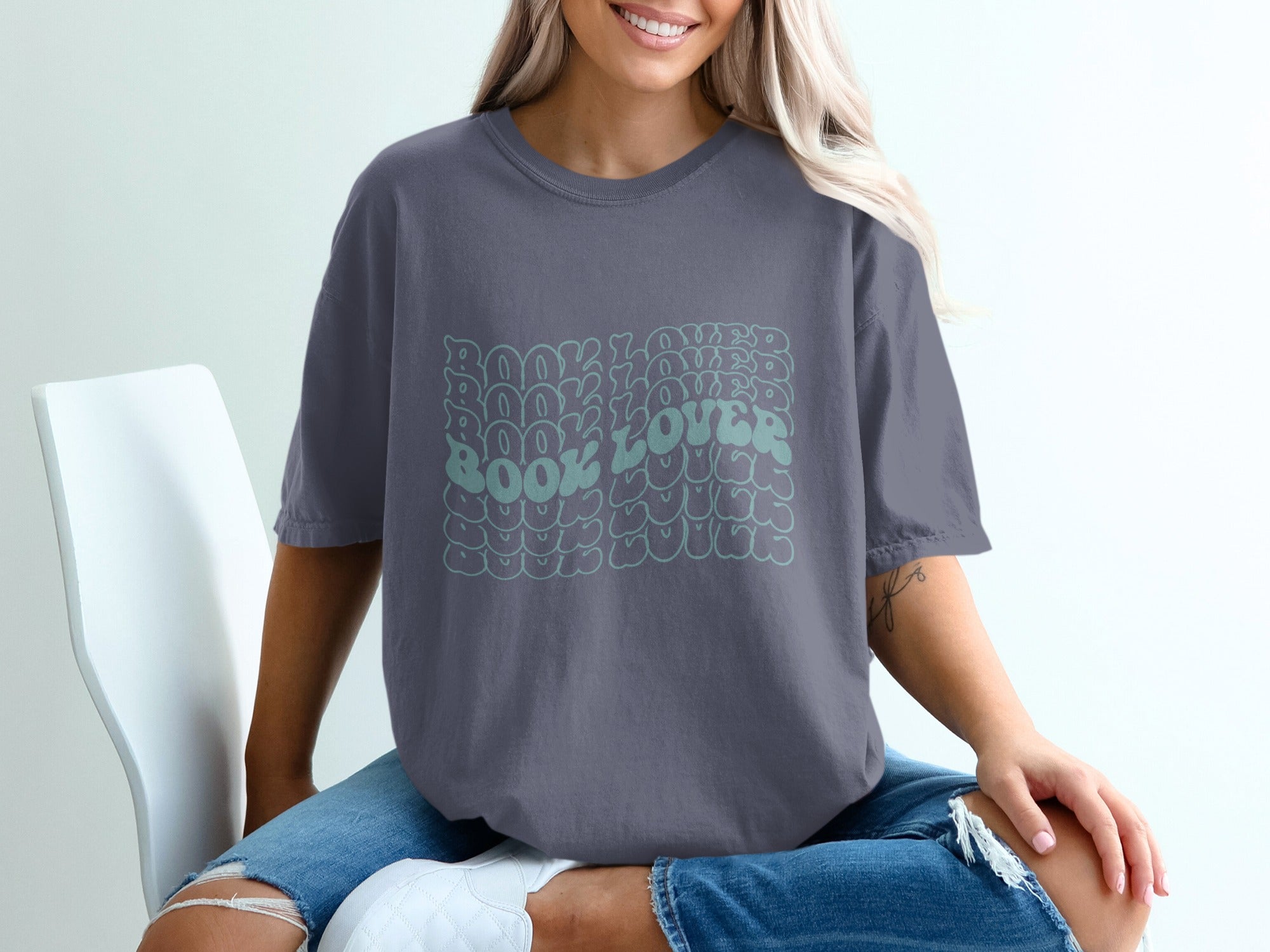 Gray t-shirt with retro wavy text reading "Book Lover" in green.