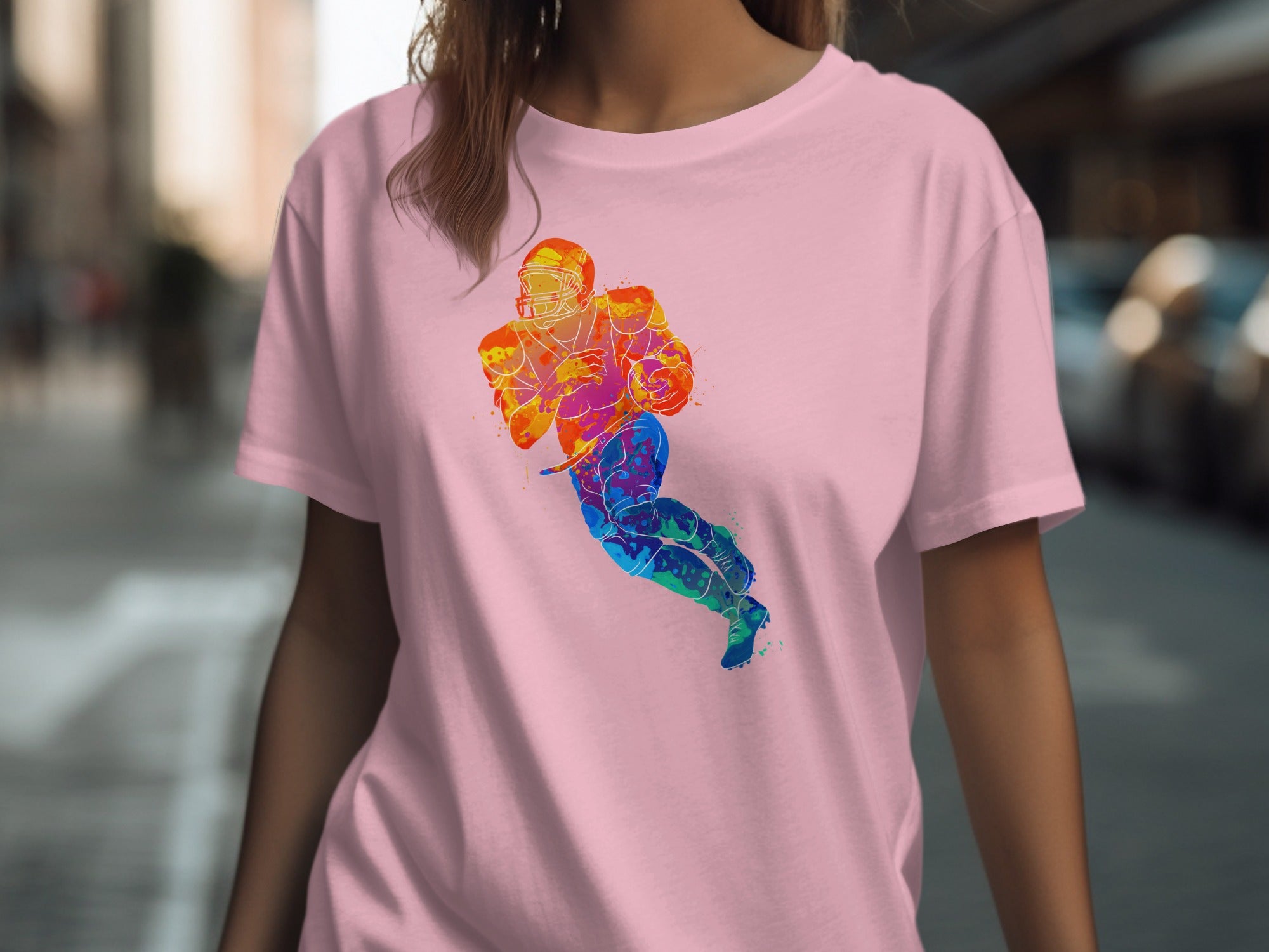Pink t-shirt featuring a colorful watercolor graphic of an American football player.