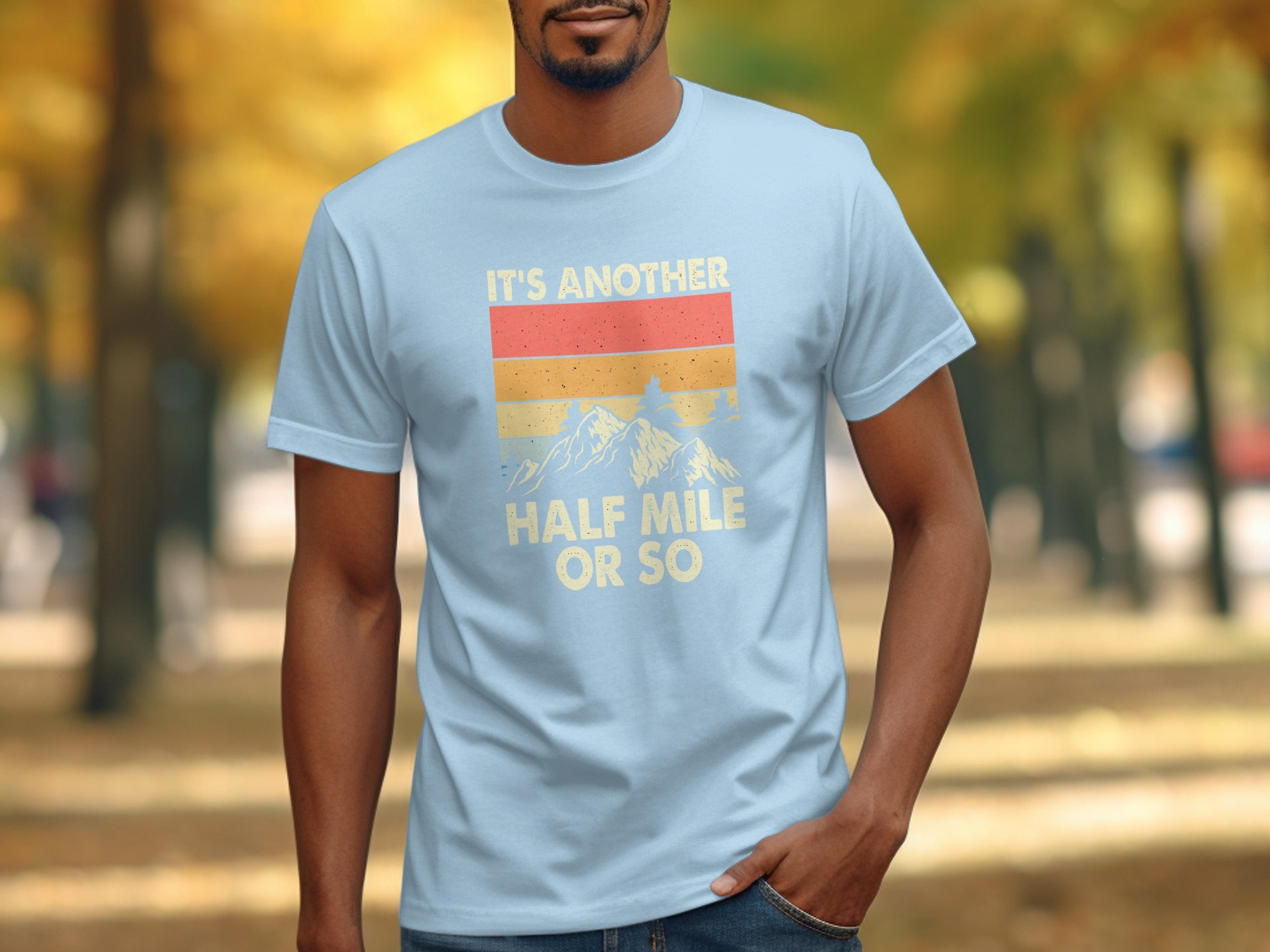 Light blue t-shirt with "IT'S ANOTHER HALF MILE OR SO" and mountain graphic.