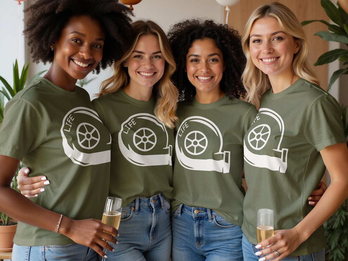 Four smiling women in green t-shirts with a white turbocharger graphic and the word "LIFE".