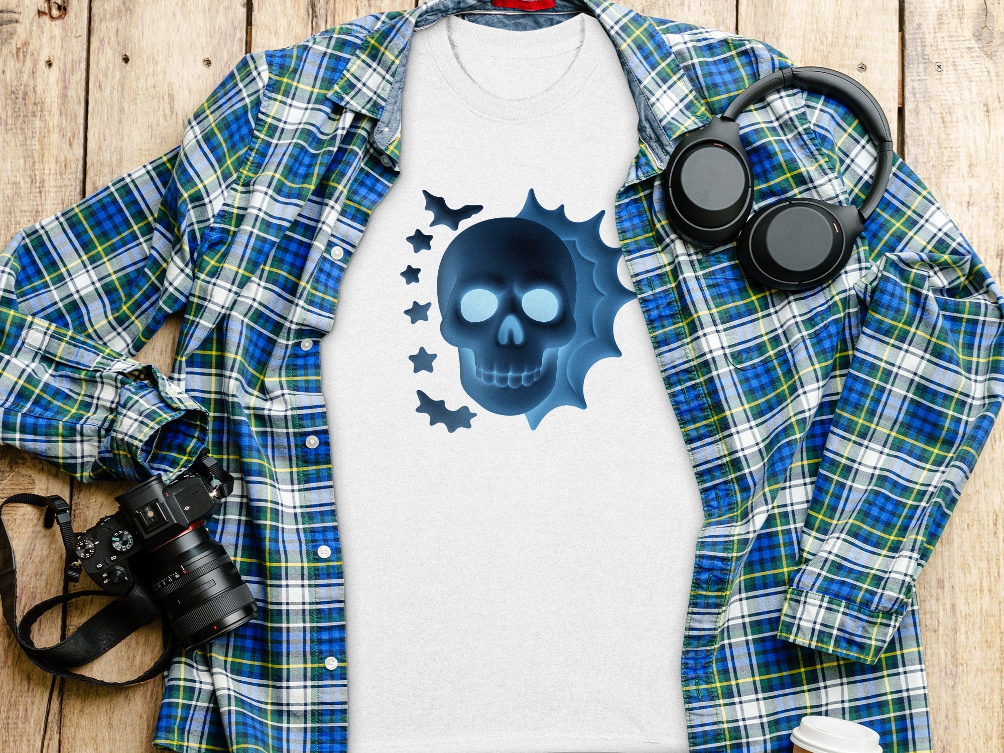 White t-shirt with blue glowing skull graphic and black headphones.