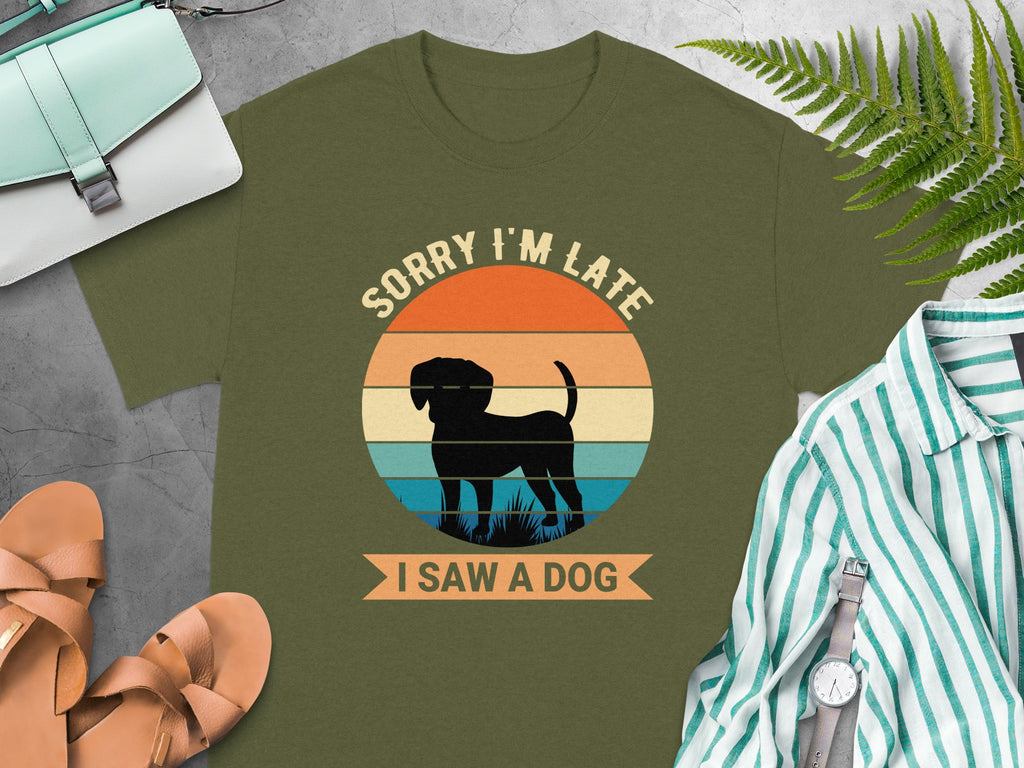 Olive green t-shirt with a circular graphic of a black dog and text "SORRY I'M LATE I SAW A DOG".