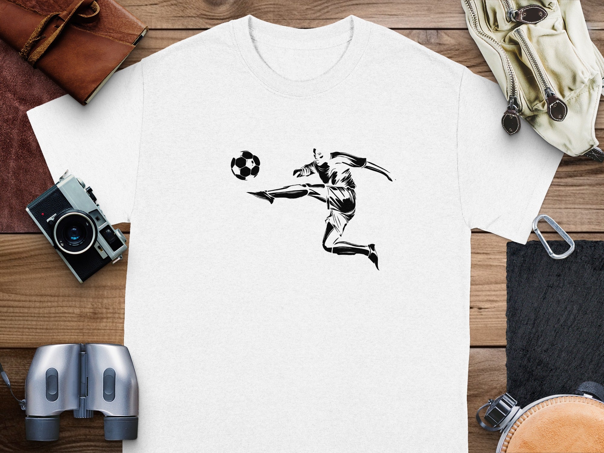 White t-shirt with black graphic of a soccer player kicking a ball.
