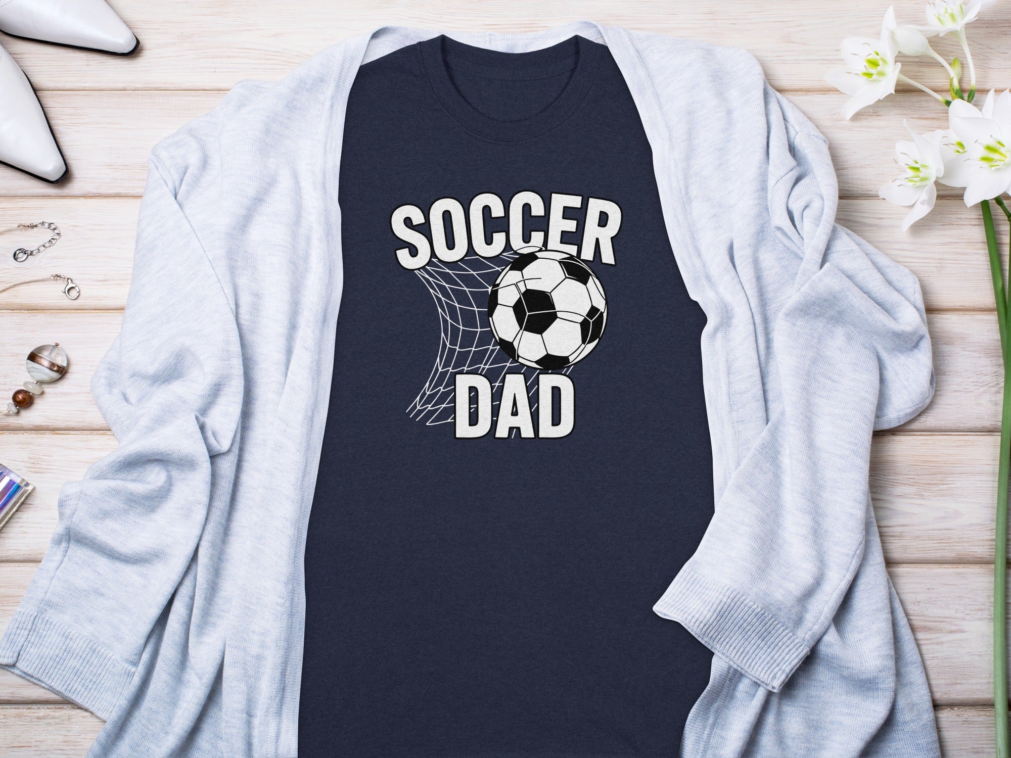 Navy t-shirt with "Soccer Dad" text and a soccer ball in a net graphic.