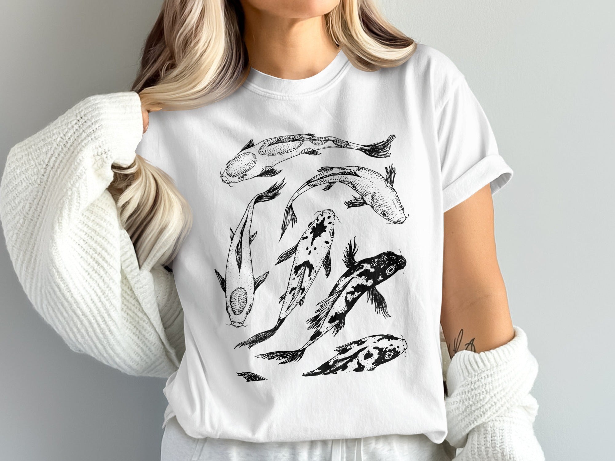 White t-shirt with a black line drawing of several koi fish.