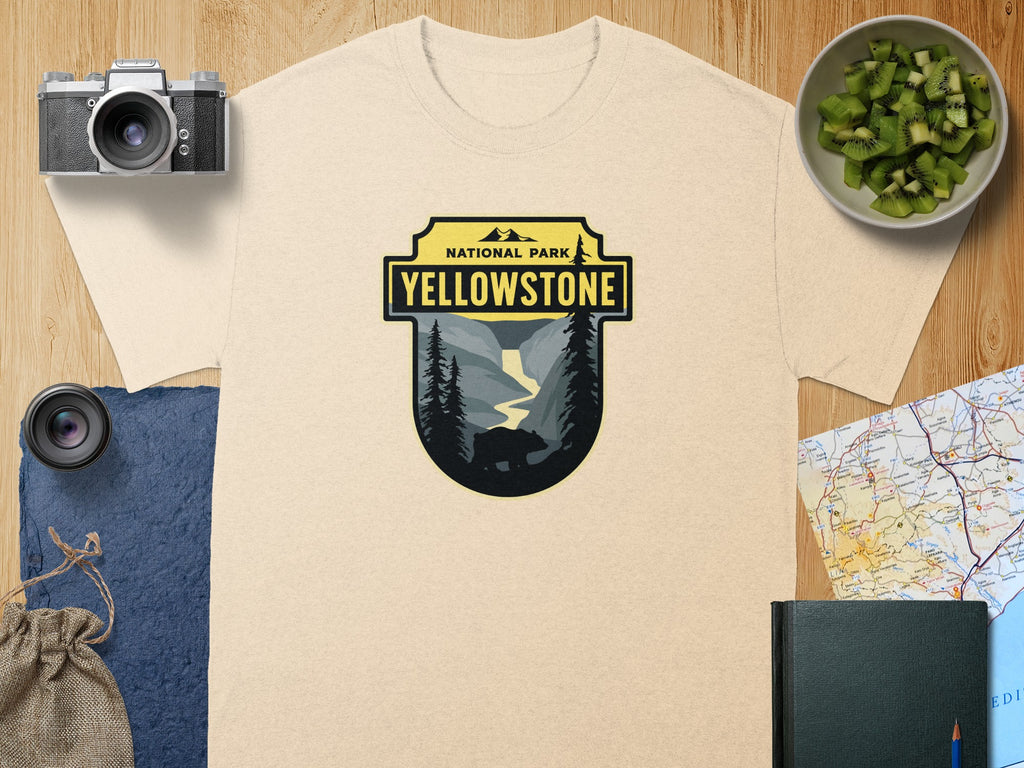 Yellowstone National Park graphic on a tan t-shirt with bear and waterfall scene.