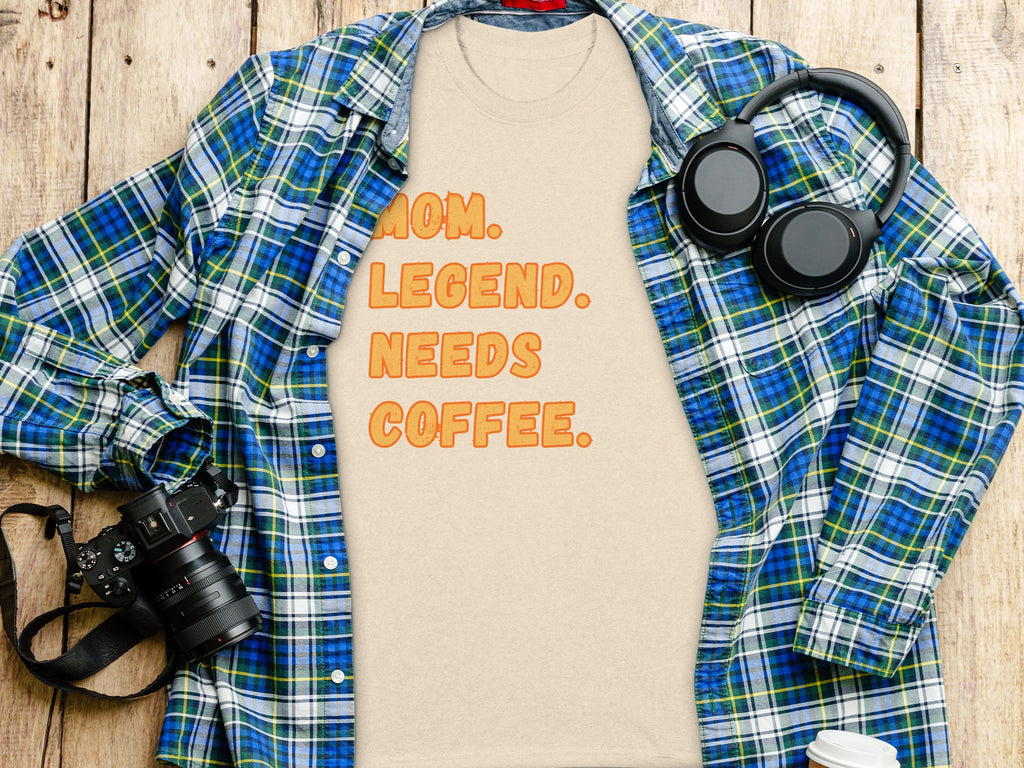 Light beige t-shirt with orange text "MOM. LEGEND. NEEDS COFFEE."