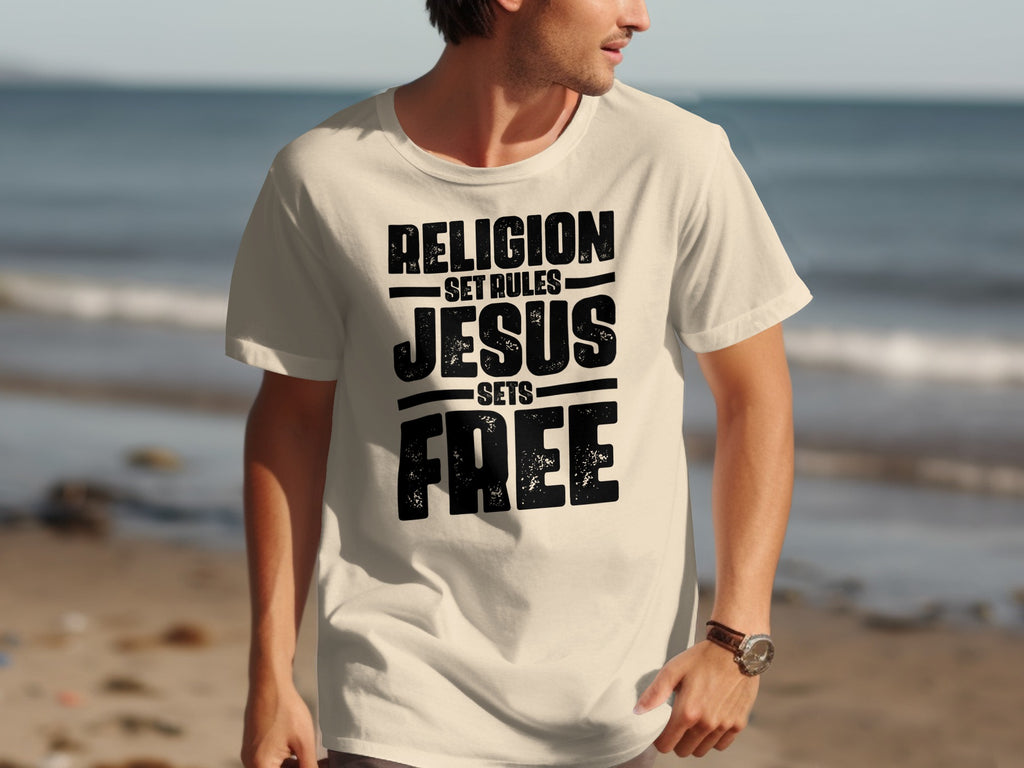 Cream t-shirt with "Religion set rules Jesus sets free" text design.