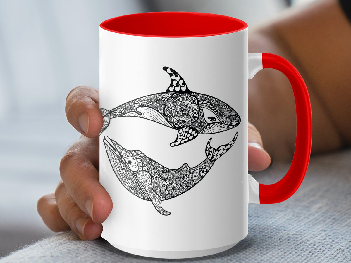 White mug with red handle featuring a black and white orca and whale design.