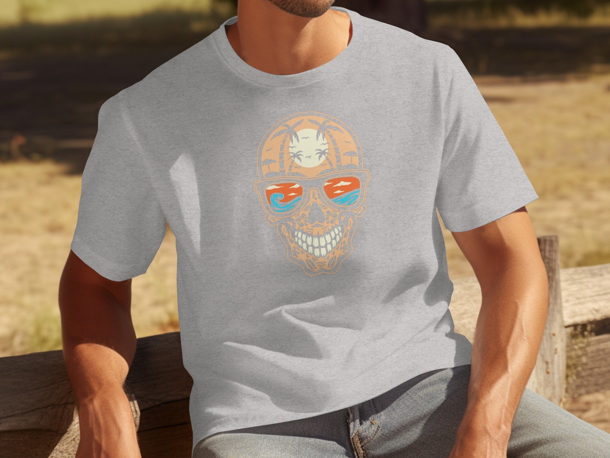 Gray t-shirt with a skull wearing sunglasses showing a beach scene.