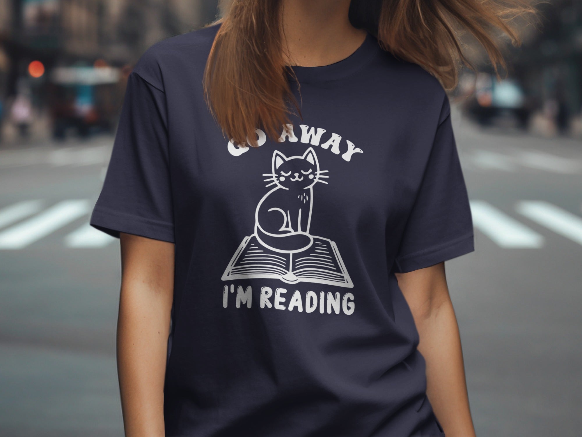 Dark blue t-shirt with "Go Away I'm Reading" and a cat on an open book.