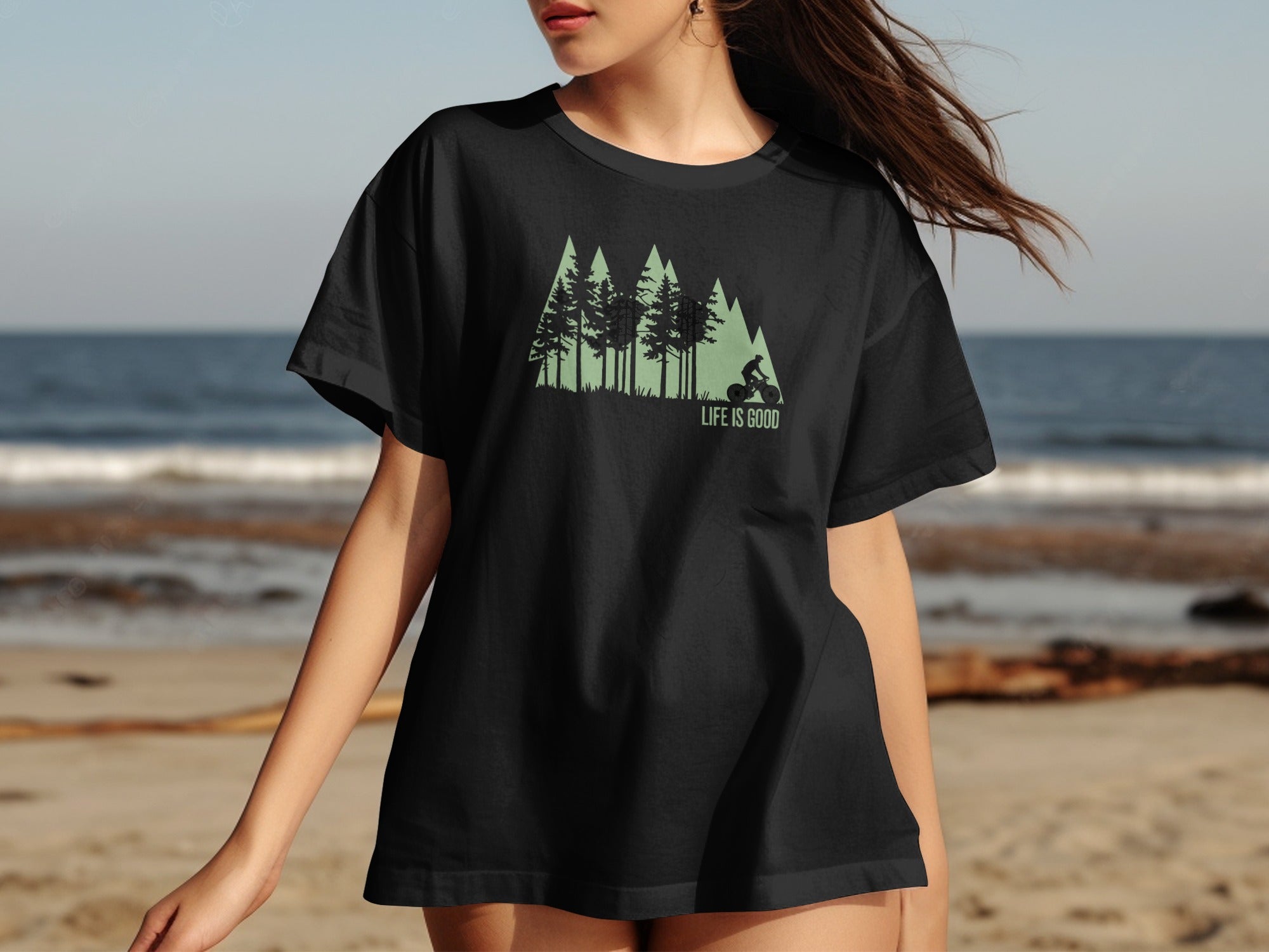 Black t-shirt with a graphic of trees, a mountain silhouette, and a cyclist, with text "LIFE IS GOOD".
