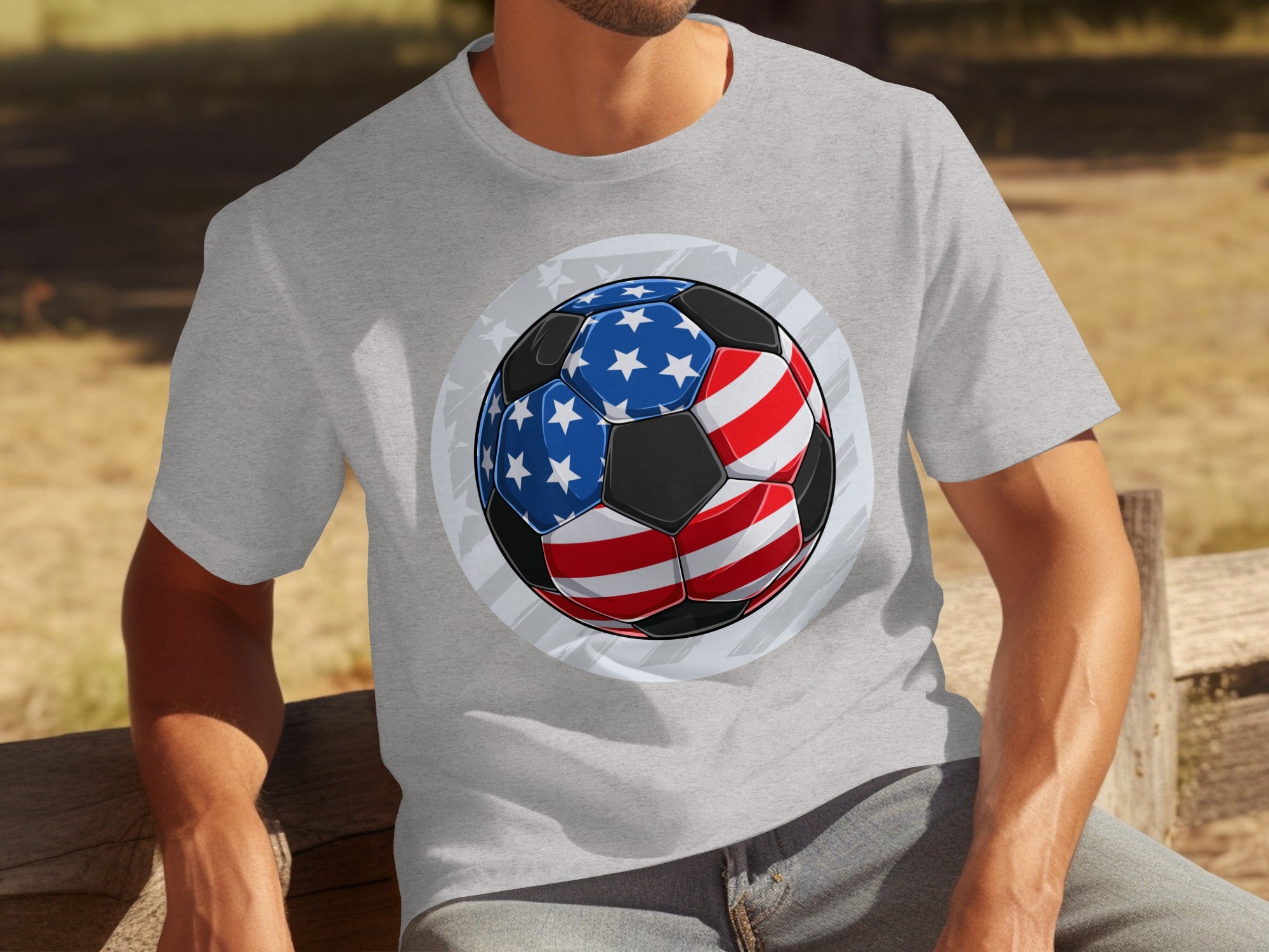 Soccer ball with USA flag design on a grey t-shirt worn by a man.