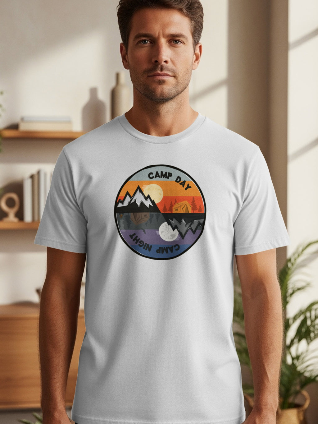 Circular logo on a white t-shirt depicts day and night camping scenes.