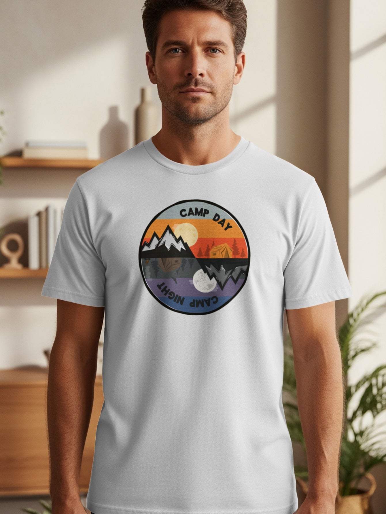 Circular logo on a white t-shirt depicts day and night camping scenes.