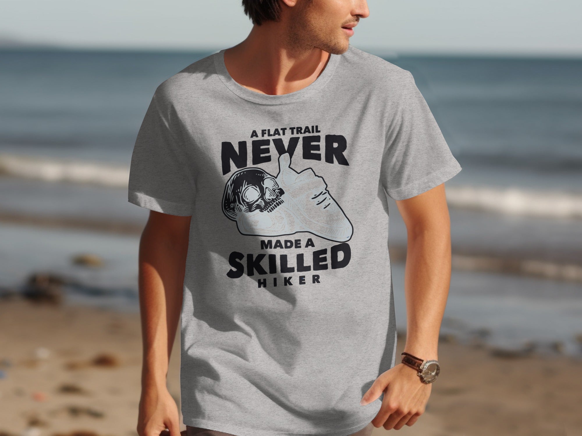 Grey t-shirt with text "A flat trail never made a skilled hiker".