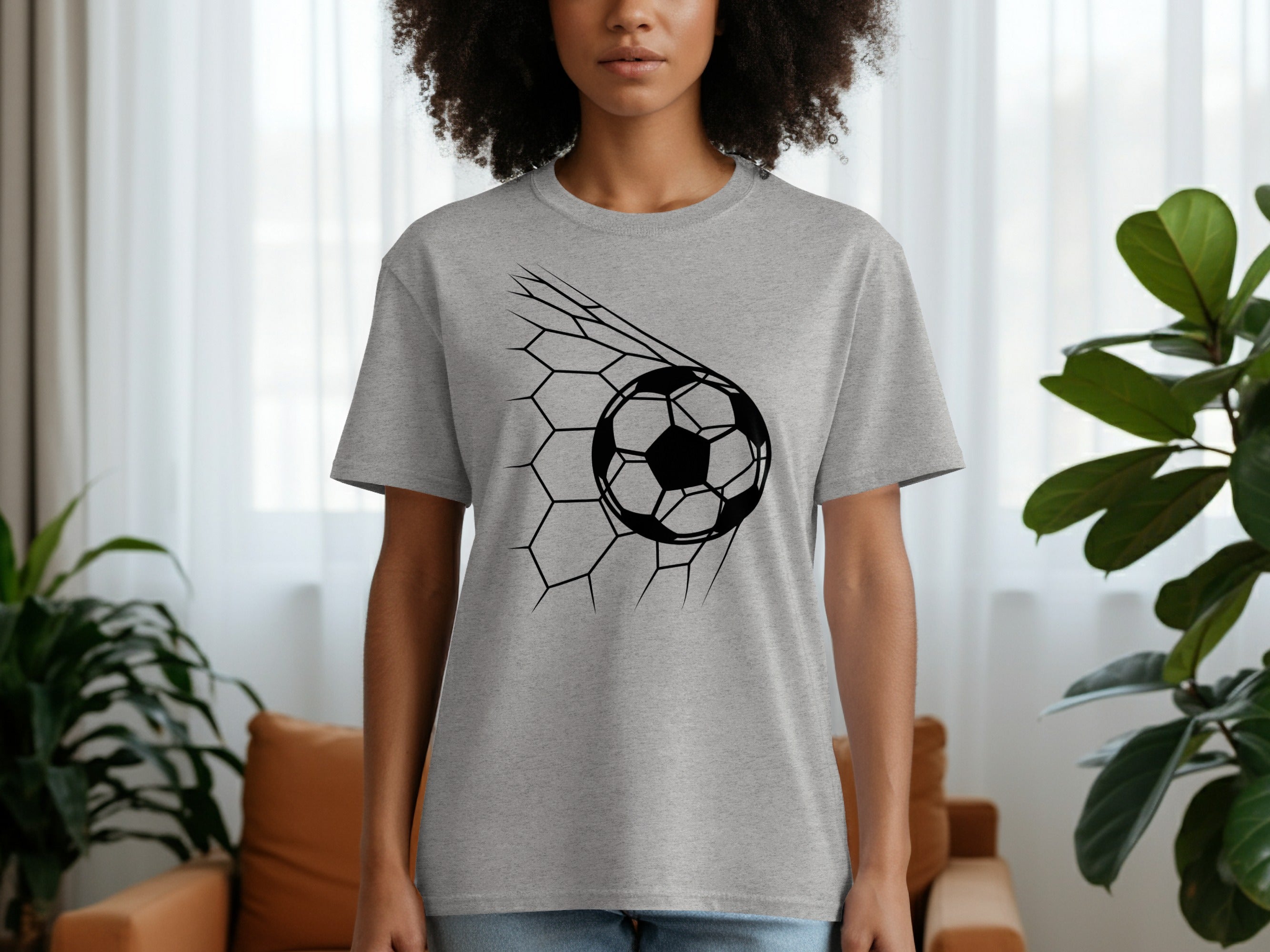 Gray t-shirt with a black soccer ball design breaking through a net.