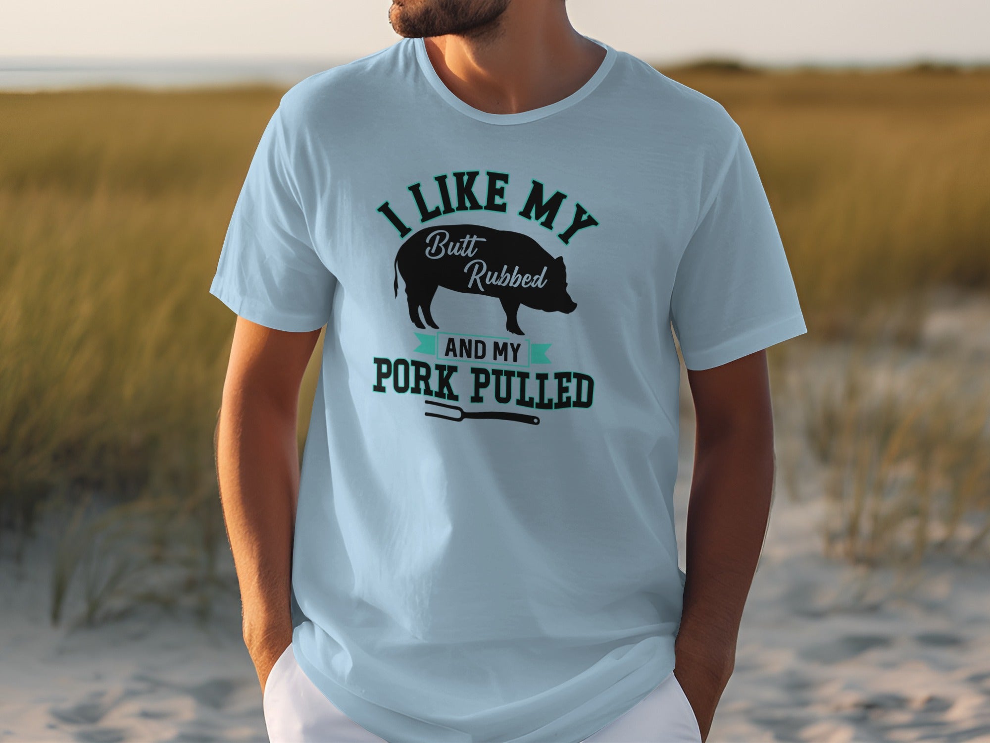 Light blue t-shirt with graphic that reads "I like my butt rubbed and my pork pulled".