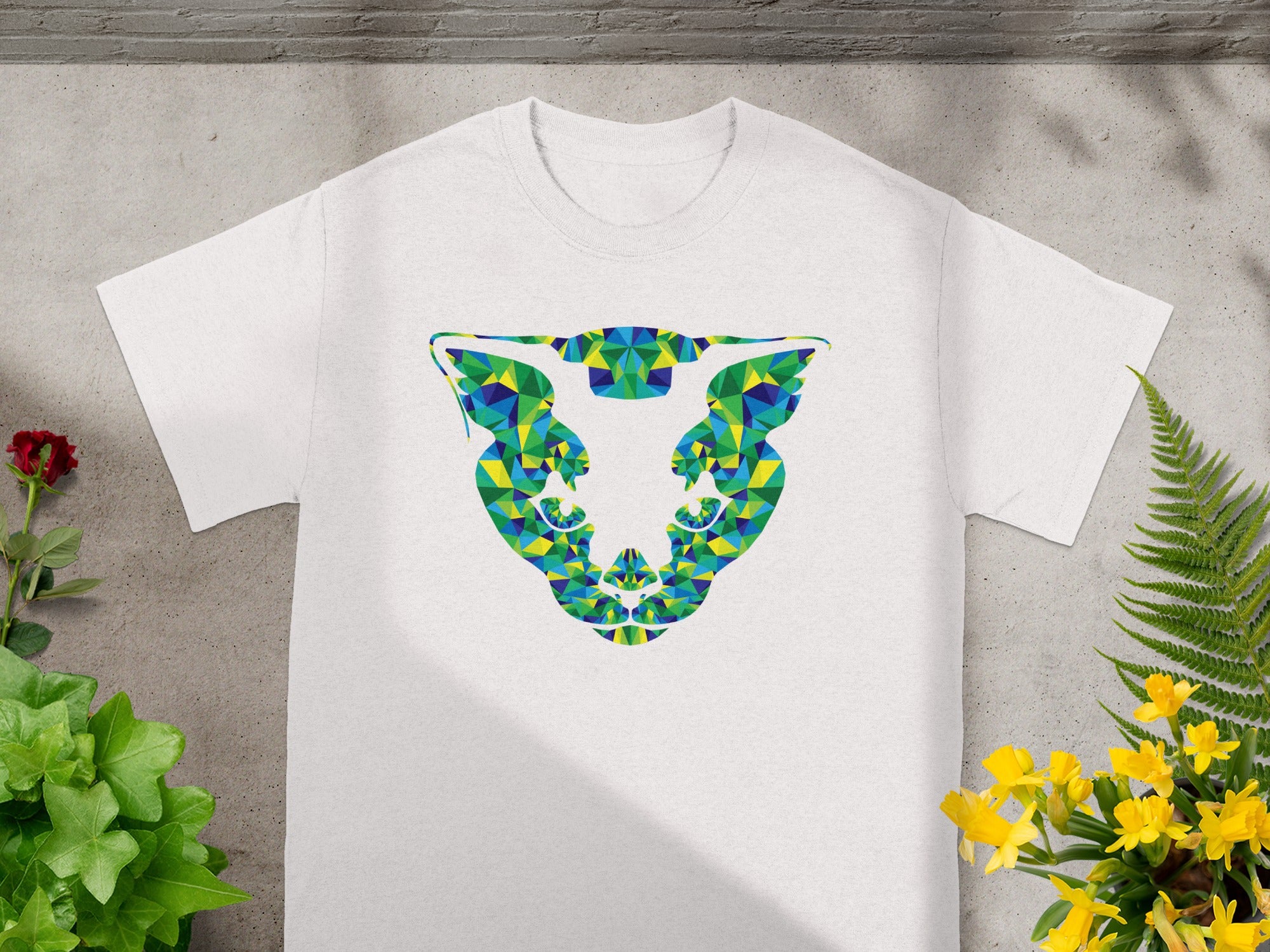 White t-shirt with a geometric jaguar head design in blue, green, and yellow.