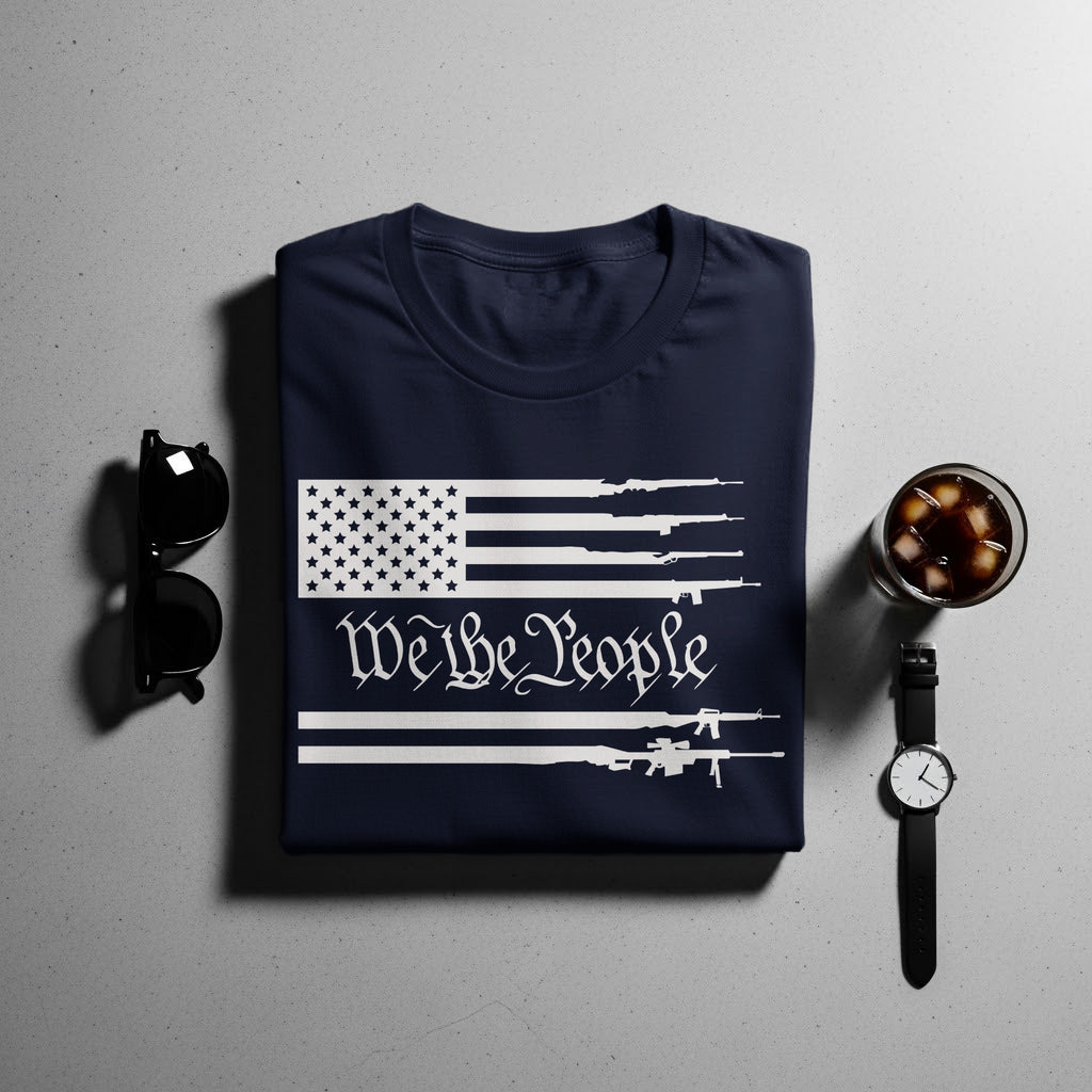Navy t-shirt with American flag design featuring guns and "We the People" text.