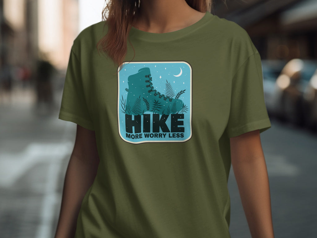 Green t-shirt with a graphic of a teal hiking boot, plants, moon, and stars.