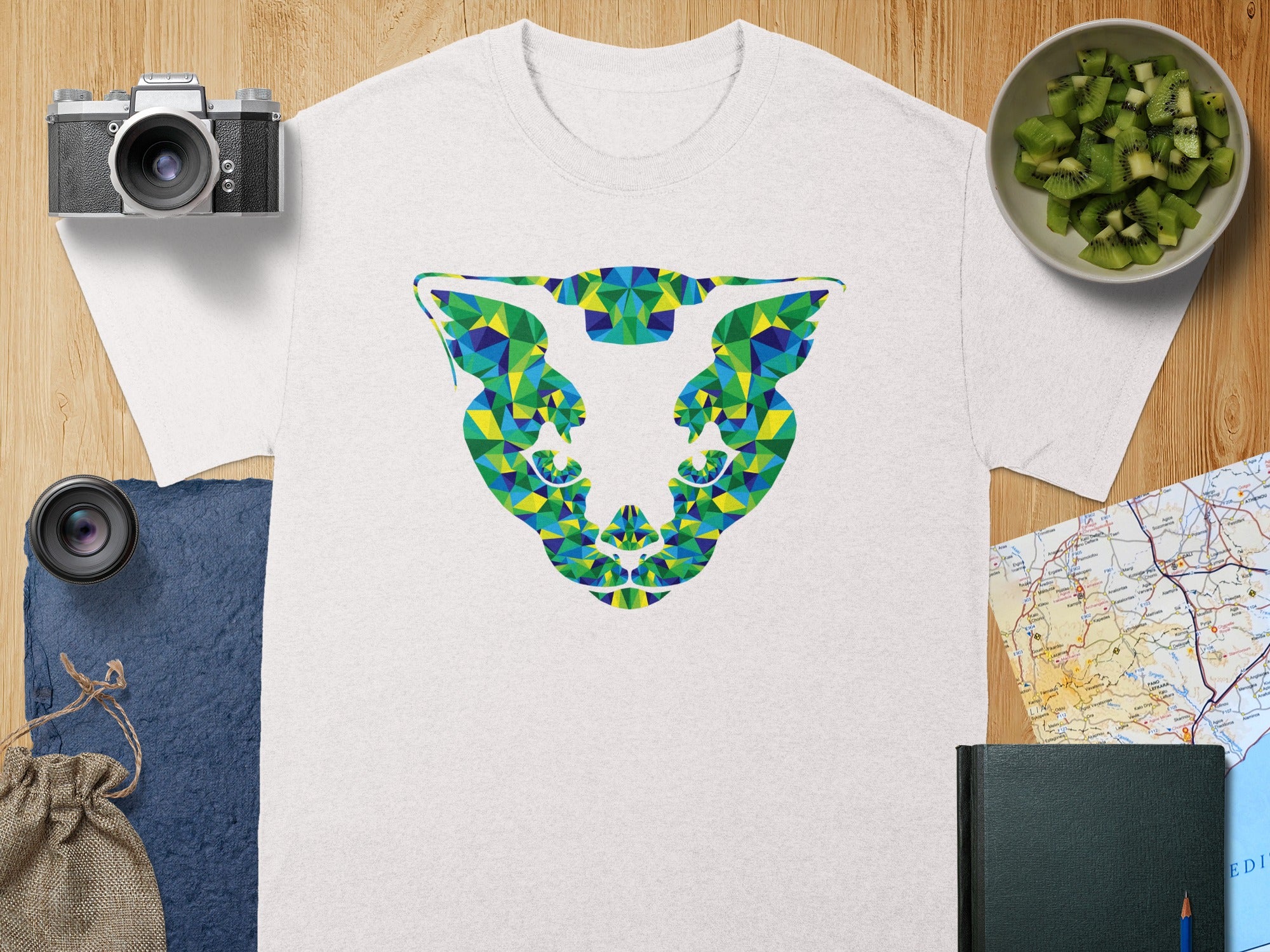White t-shirt with abstract geometric lion head design in blue, green, and yellow.