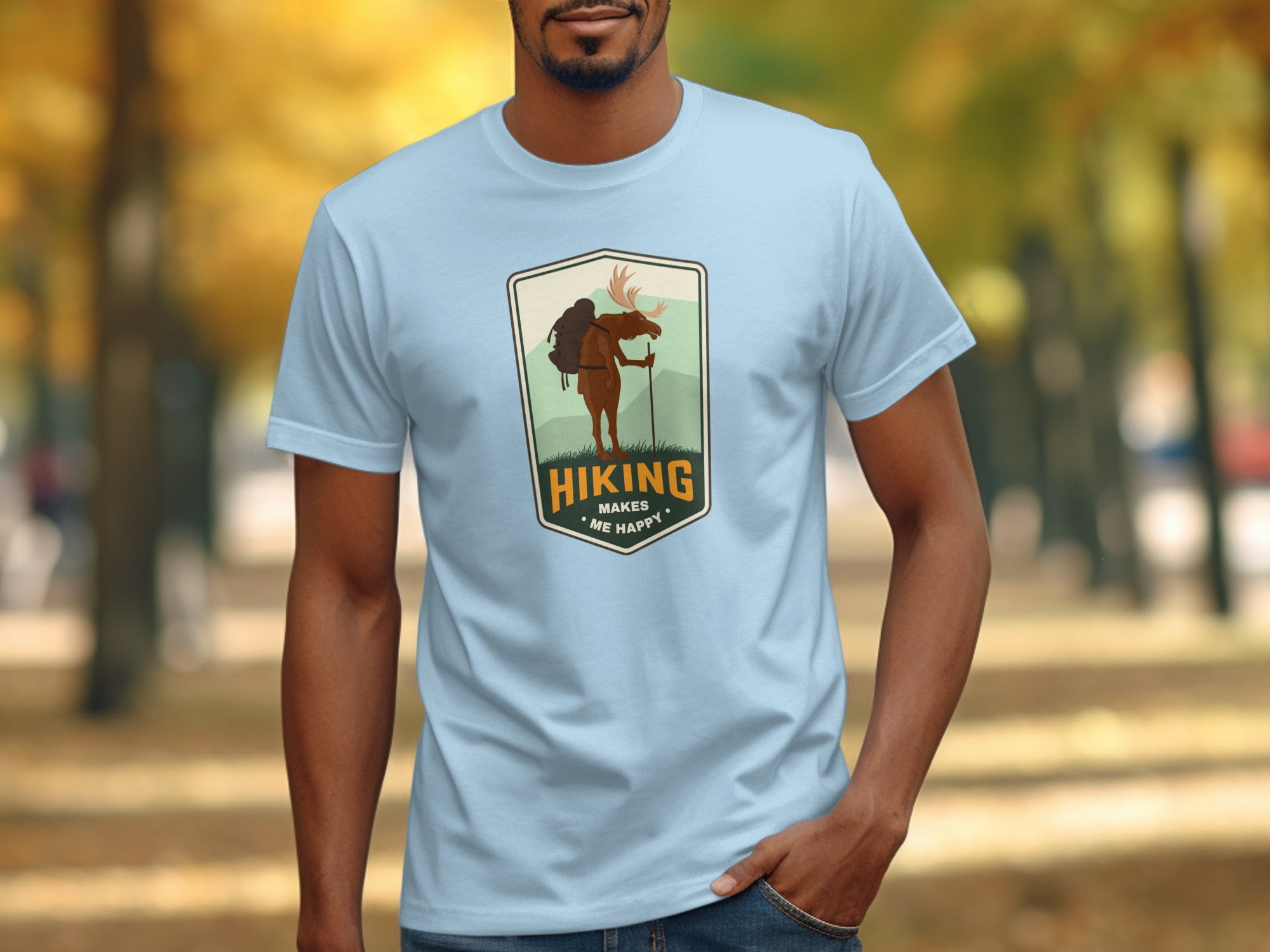 Light blue t-shirt with a moose graphic and text "Hiking Makes Me Happy".