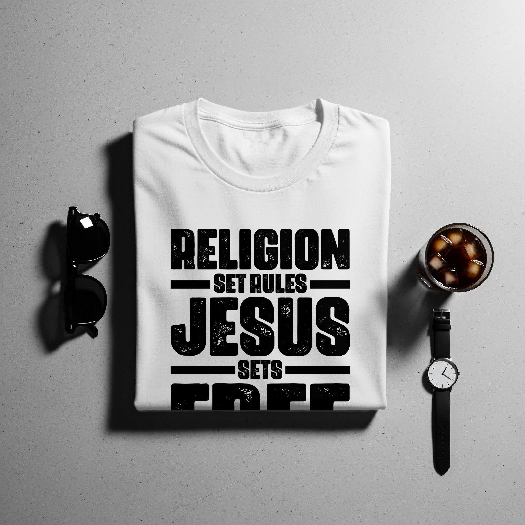 White t-shirt with text "Religion sets rules, Jesus sets free"