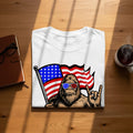 Bigfoot wearing patriotic sunglasses holds an American flag and makes rock-on hand gesture.