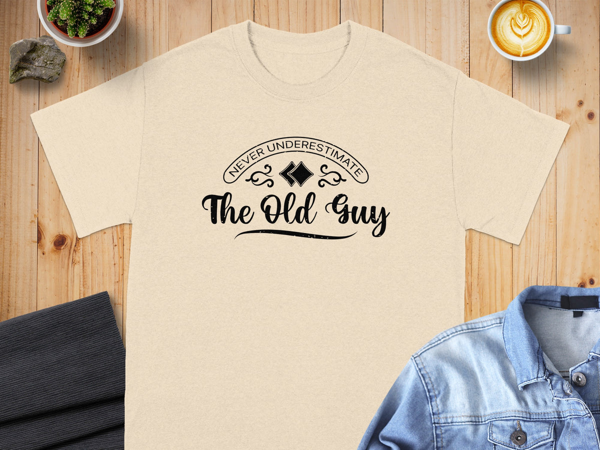Light beige t-shirt with "Never Underestimate The Old Guy" text graphic.