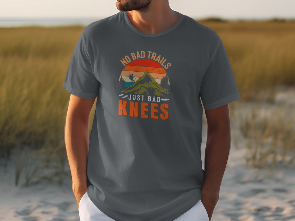 Dark grey t-shirt with "NO BAD TRAILS JUST BAD KNEES" text and mountain graphic.