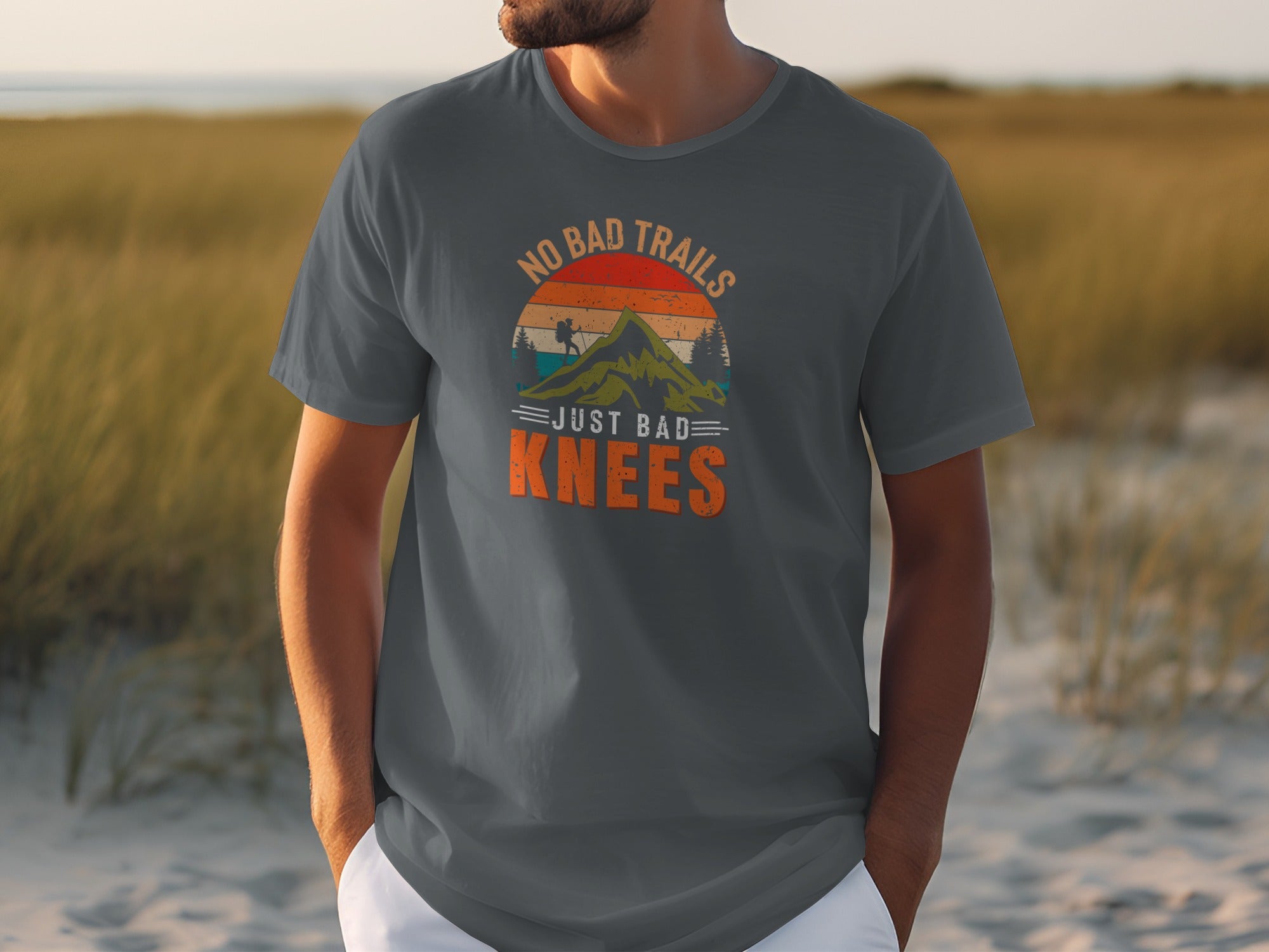 Dark grey t-shirt with "NO BAD TRAILS JUST BAD KNEES" text and mountain graphic.