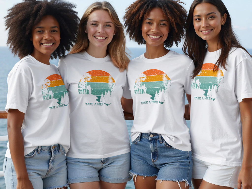 Four women wear white t-shirts with a "Take a Hike" sunset graphic.