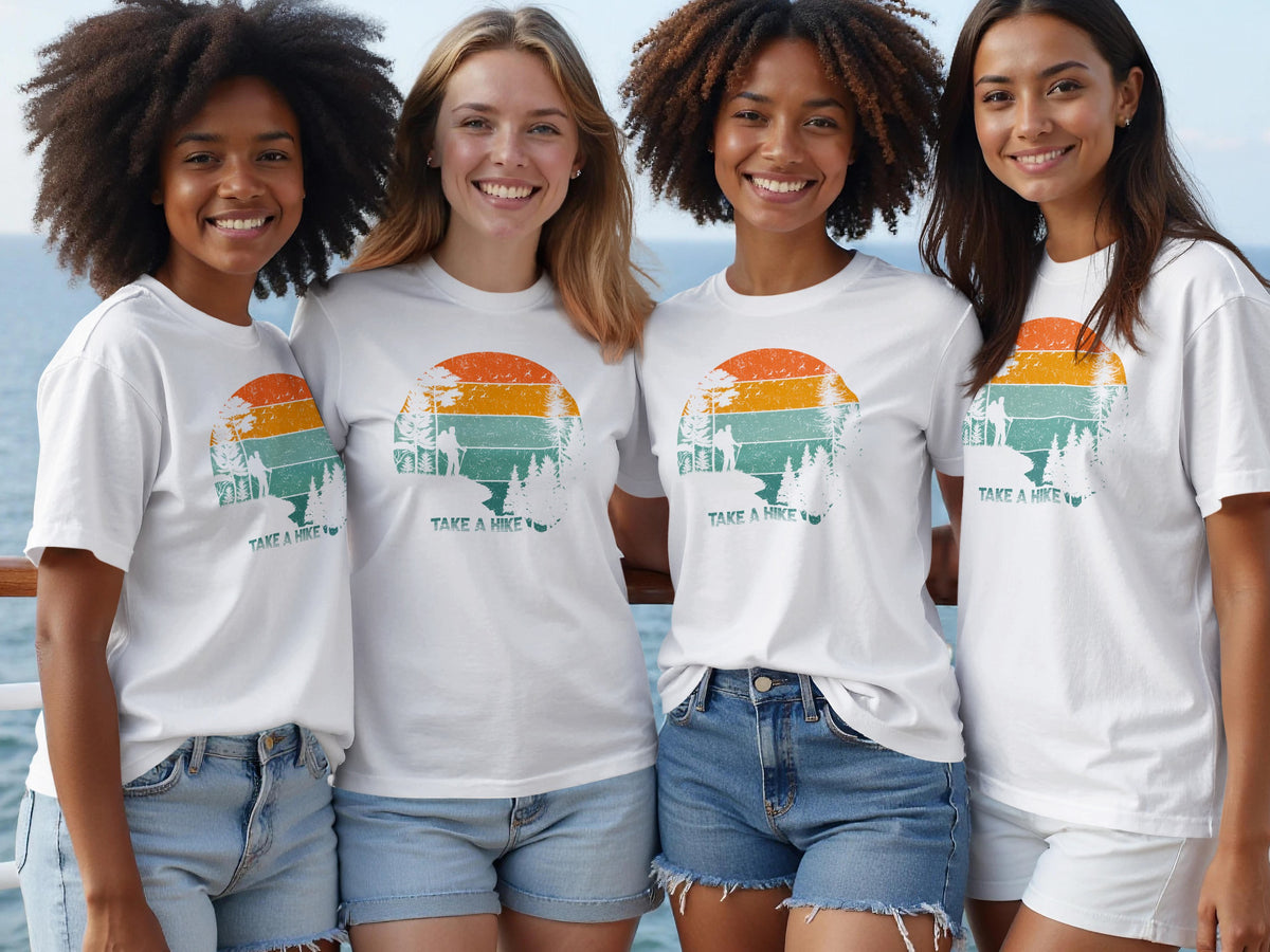 Four women wear white t-shirts with a "Take a Hike" sunset graphic.
