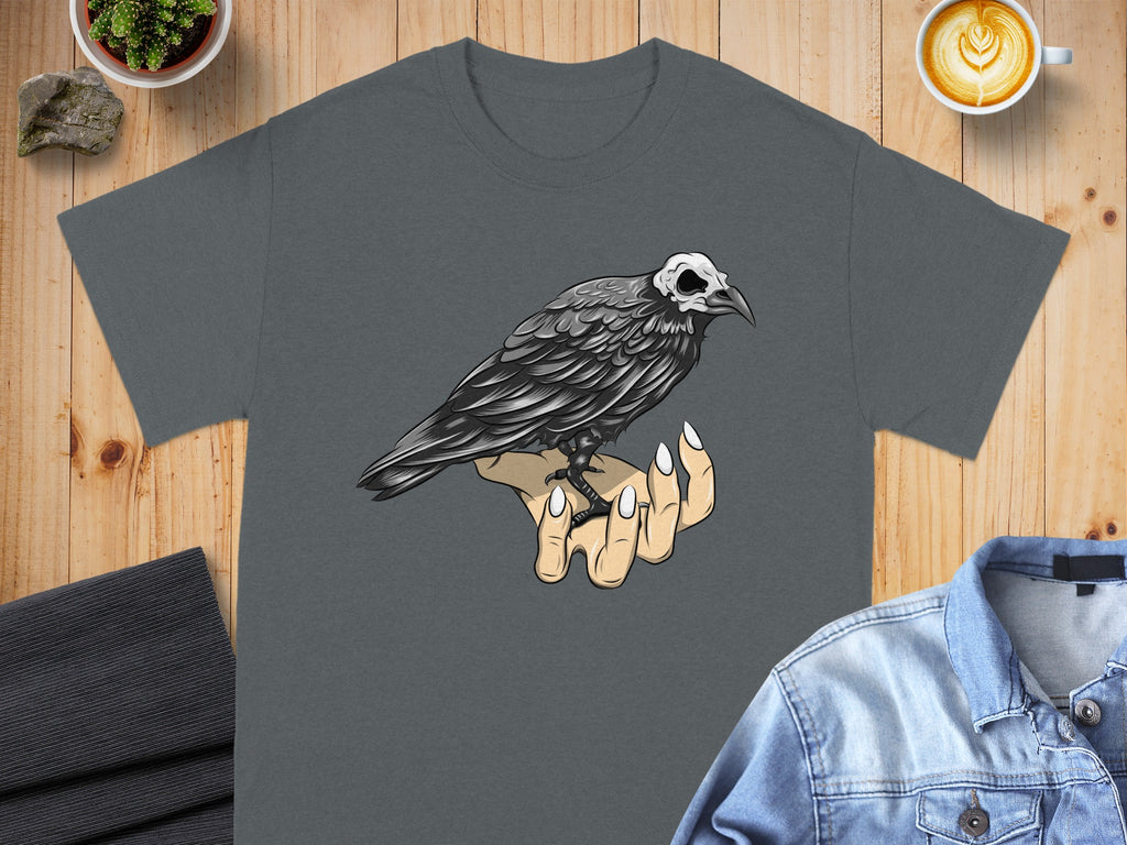 Dark grey t-shirt with a crow with a skull head perched on a hand.