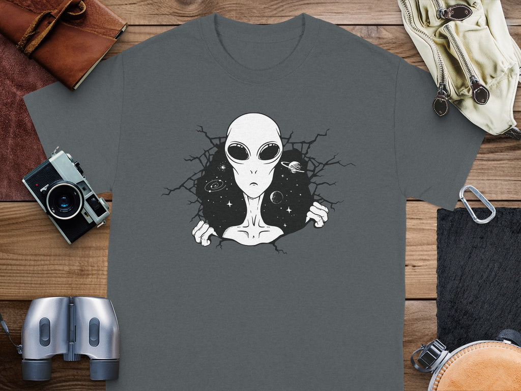 T-shirt with a drawing of an alien emerging from a cracked space background.