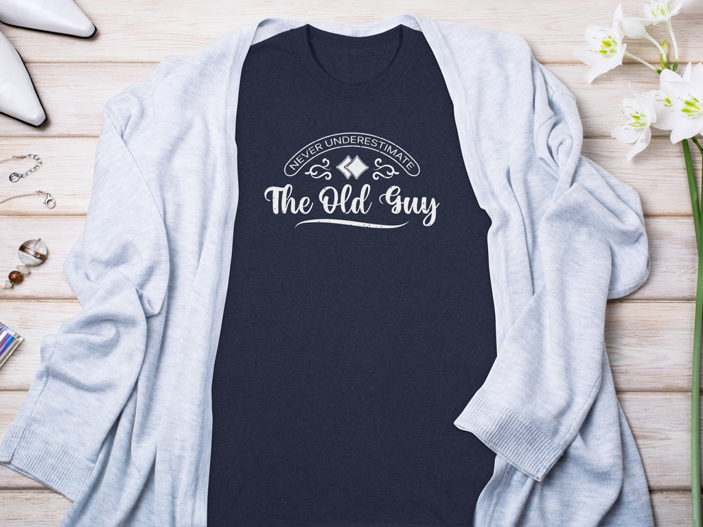 Navy t-shirt with white text reading "Never Underestimate The Old Guy".