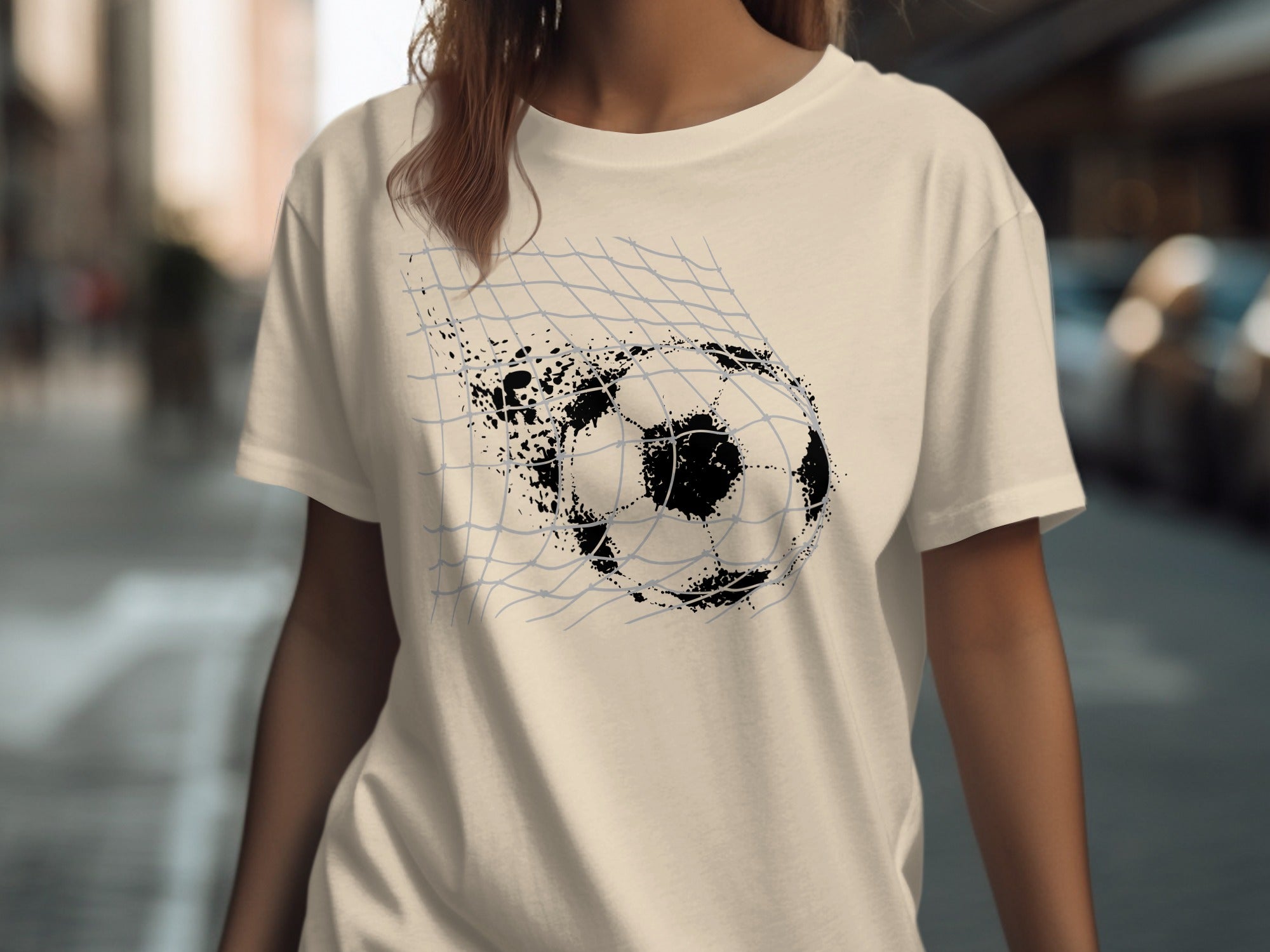 Light t-shirt with a graphic of a distressed soccer ball breaking through a net.