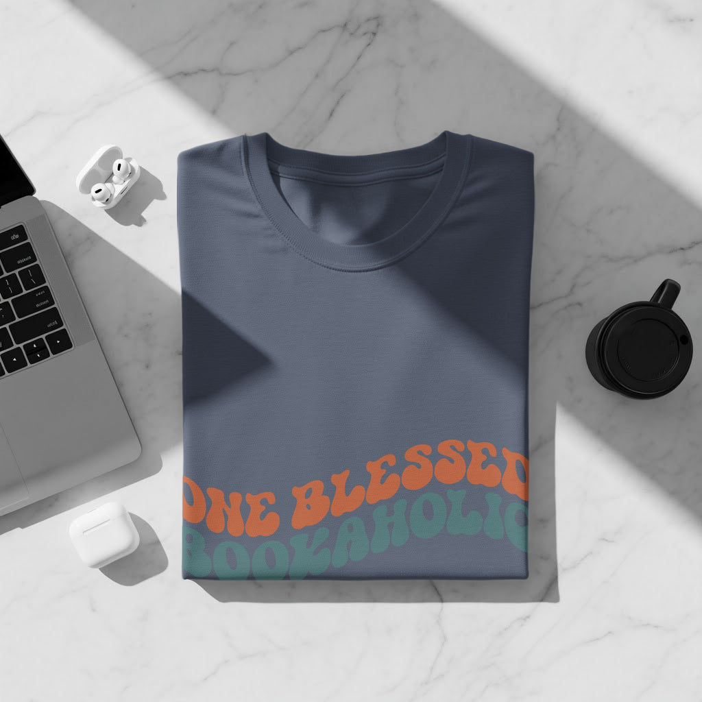 Navy t-shirt with orange and teal "ONE GODLESS BOOKAHOLIC" text.
